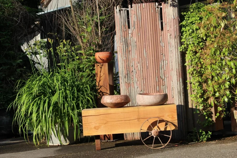 Steinschalen auf einem Holzkarren vor dem Atelier