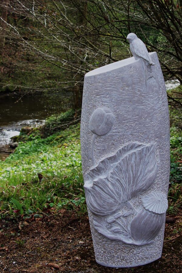 Gedenkstein mit Blumenrelief und Vogel