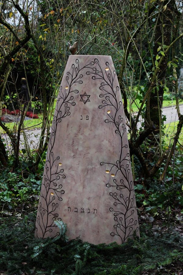 Gedenkstein mit Relief im Grünen