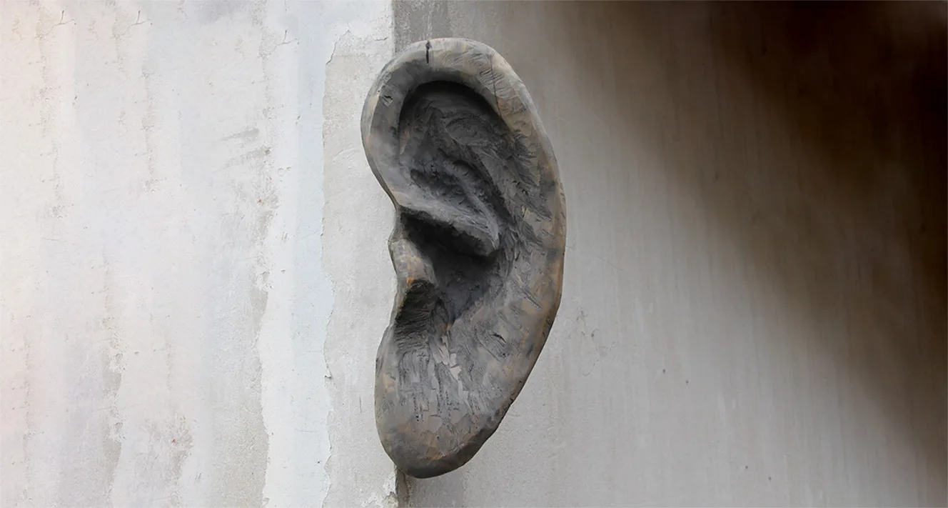 Skulptur eines Ohrs an einer Wand